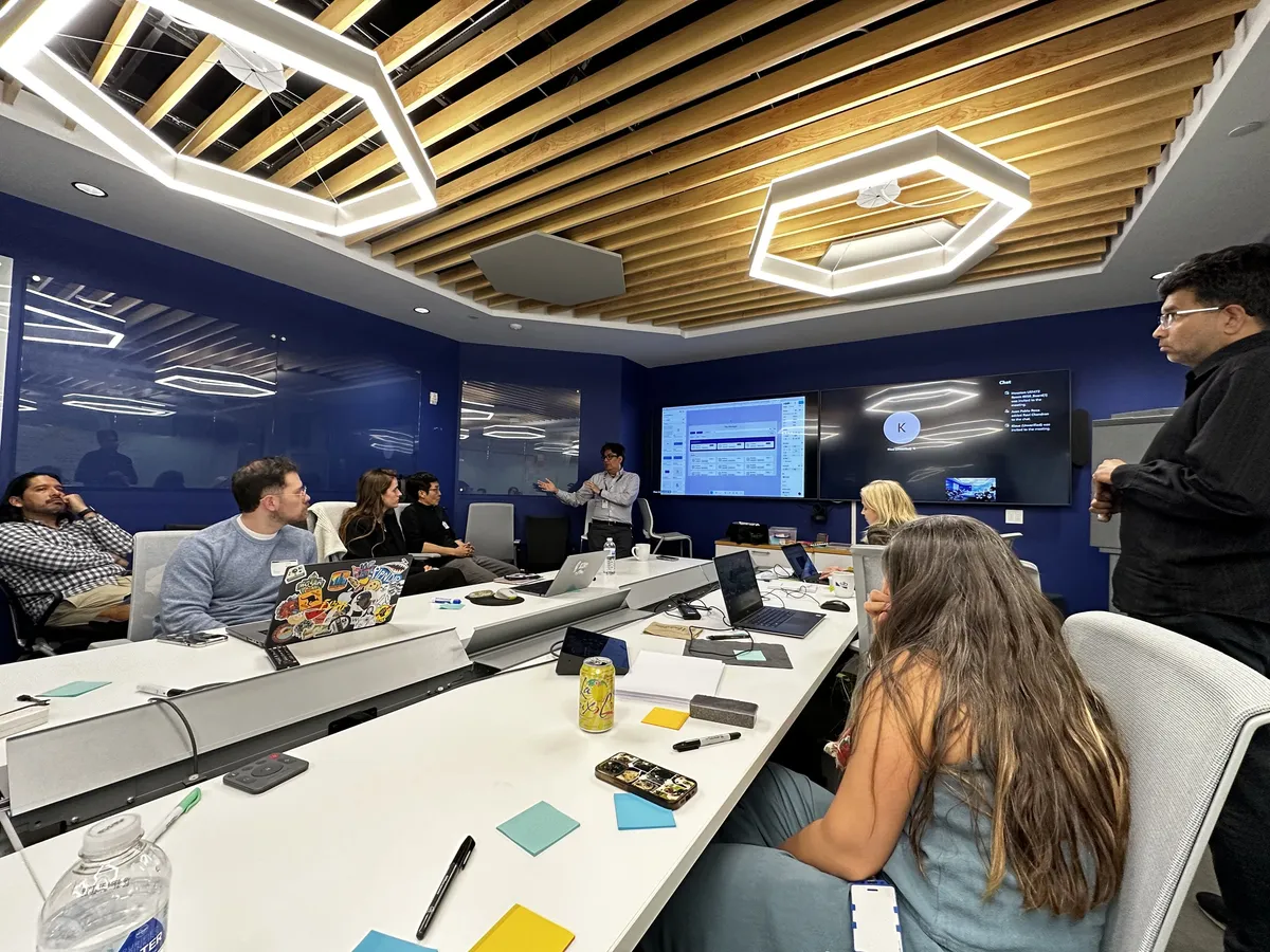 A review in a client conference room, a manager presenting the product on the screens under the hexagonal lights.